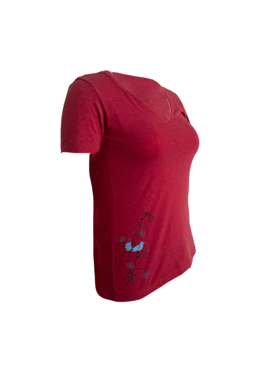 T-shirt rouge en coton biologique avec un imprimé fleurs et oiseaux au bas coté droit.
