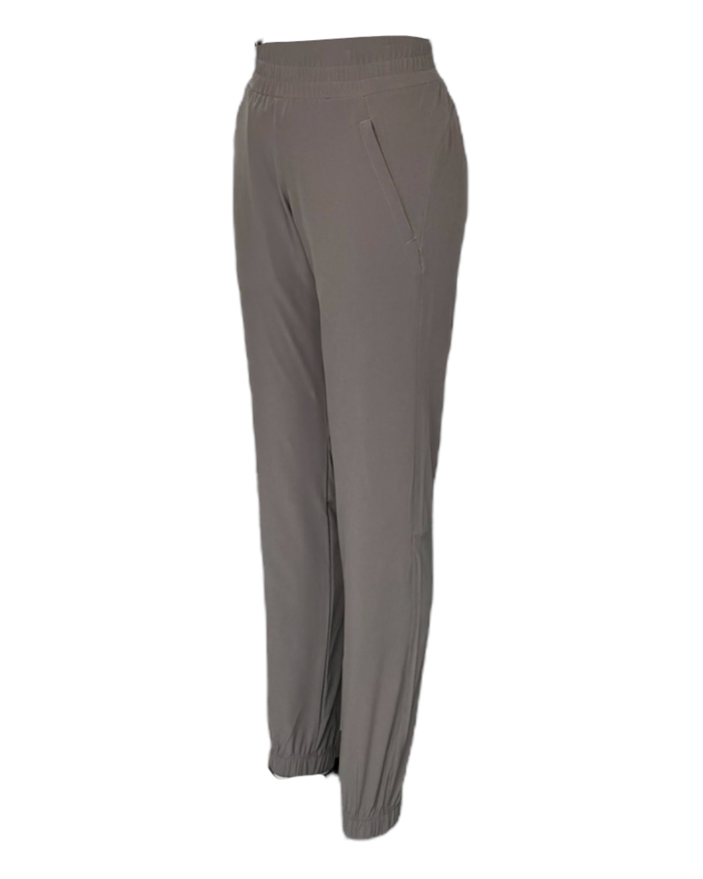 Un pantalon taupe extensible pour femme avec taille élastique avec cordon d'ajustement et élastique su bas de la jambe, idéal pour le voyage
