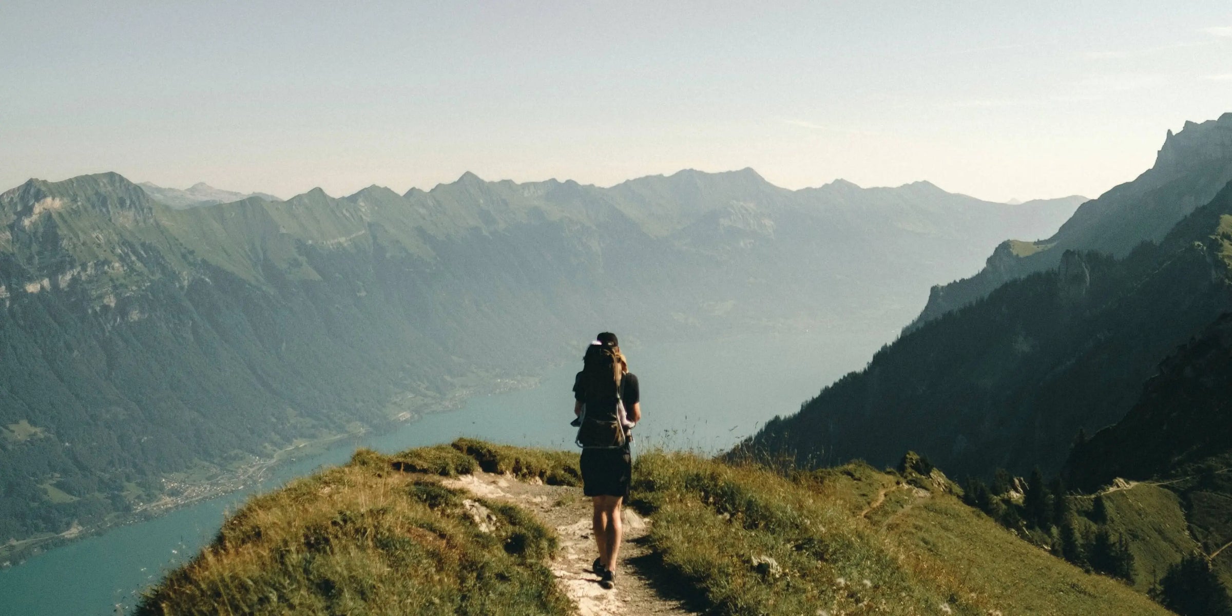 Femme faisant une randonnée avec des vêtements Vertical Sports face aux montagnes et à des gorges. 